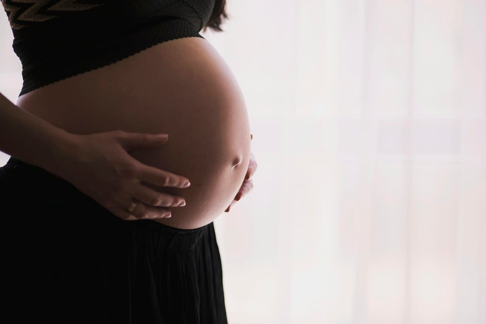 A pregnant woman cradling her belly